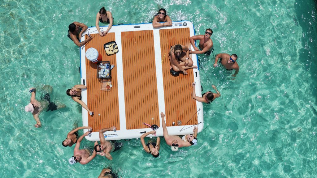 Overhead view of guests in the water around a floating mat