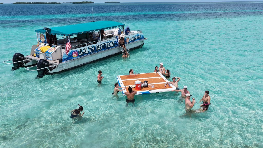 Aerial view of the Salty Bottom party boat with guests swimming around a floating mat